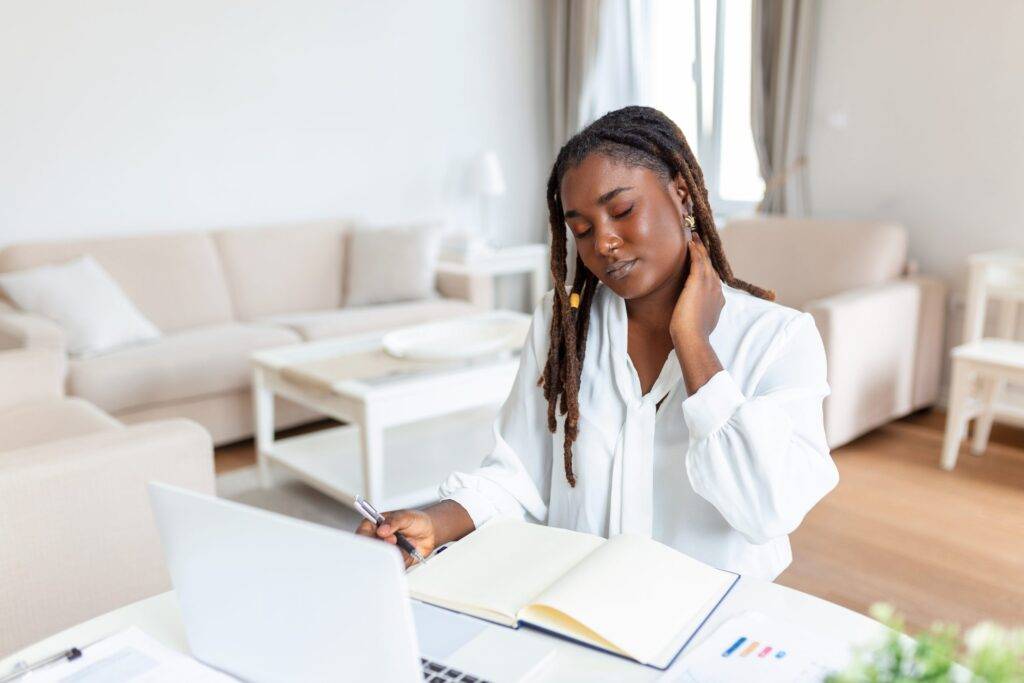 Tired and frustrated young African female doctor showing signs of depression.