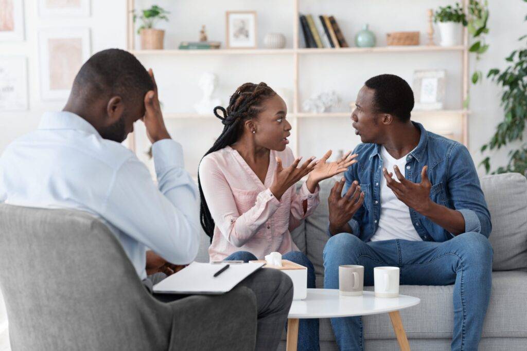 black couple arguing in family therapy with counselor. Incessant conflicts and problems in your relationship is one of the signs you need to see a therapist.