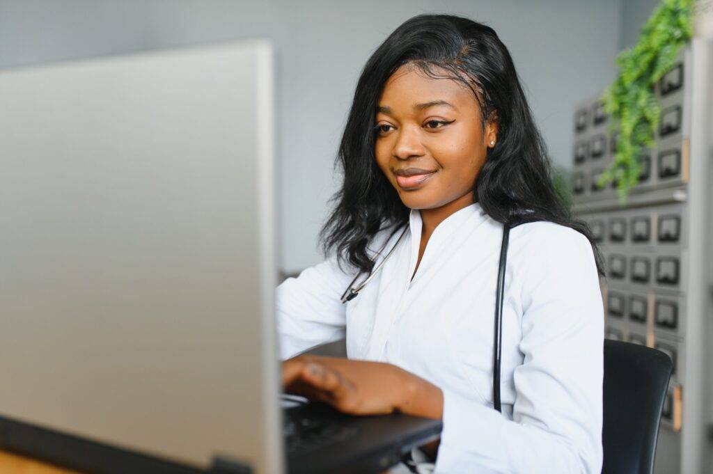 African female doctor make online telemedicine video call consult patient. Afro american black woman therapist talking to camera in remote videoconference chat.