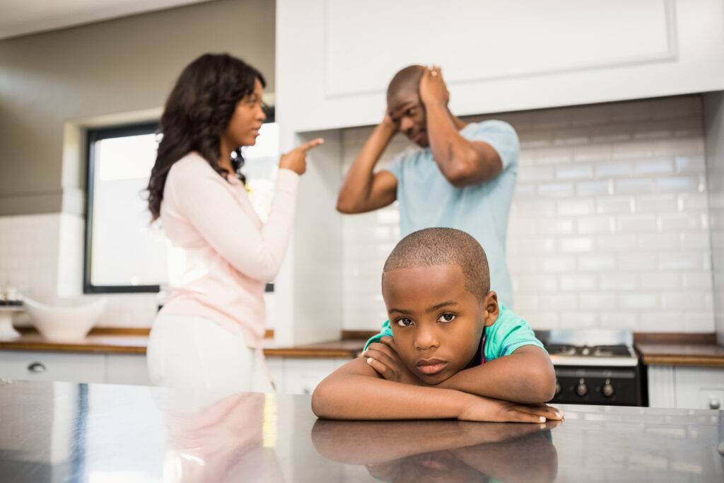 Parents arguing in front of son in the kitchen.